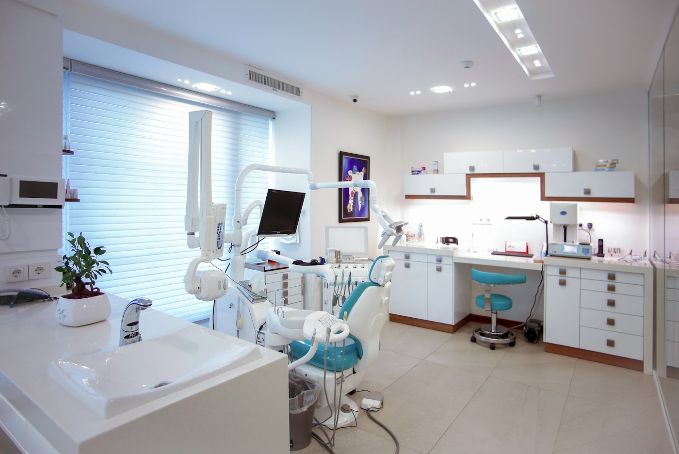 Modern dental room with teal chair and wash basin