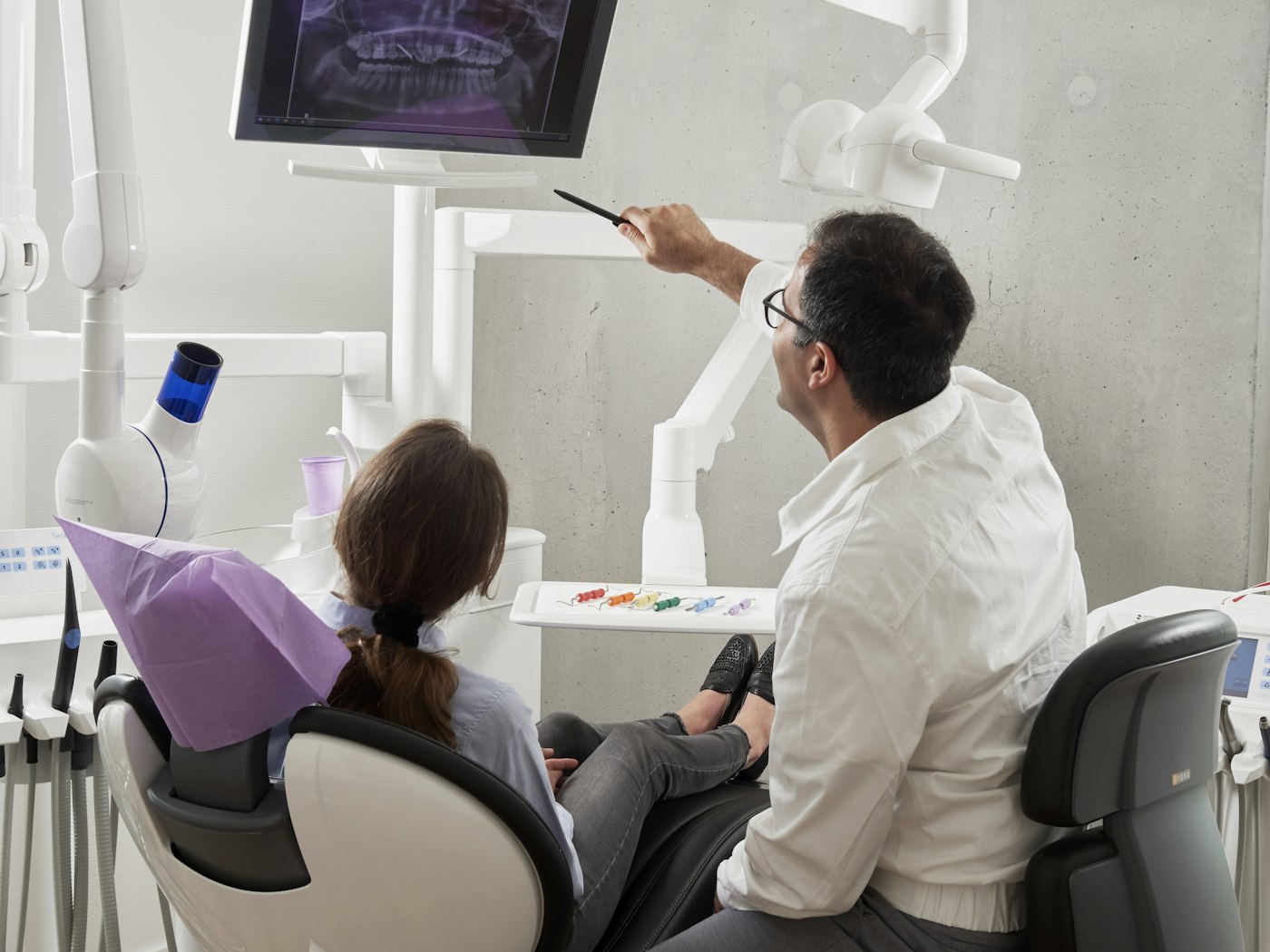 Dentist explaining an X-ray to a patient in a modern clinic